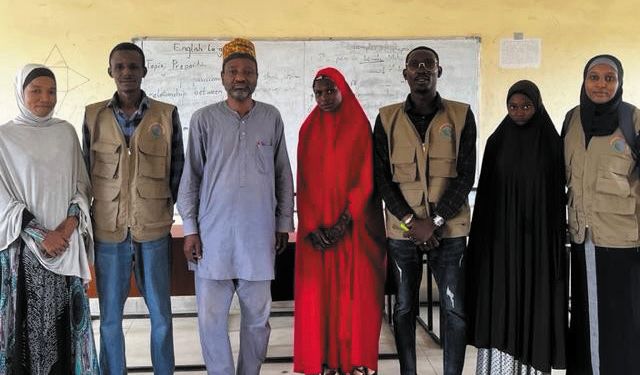 ZAIDF team members and school staff pose together in a classroom