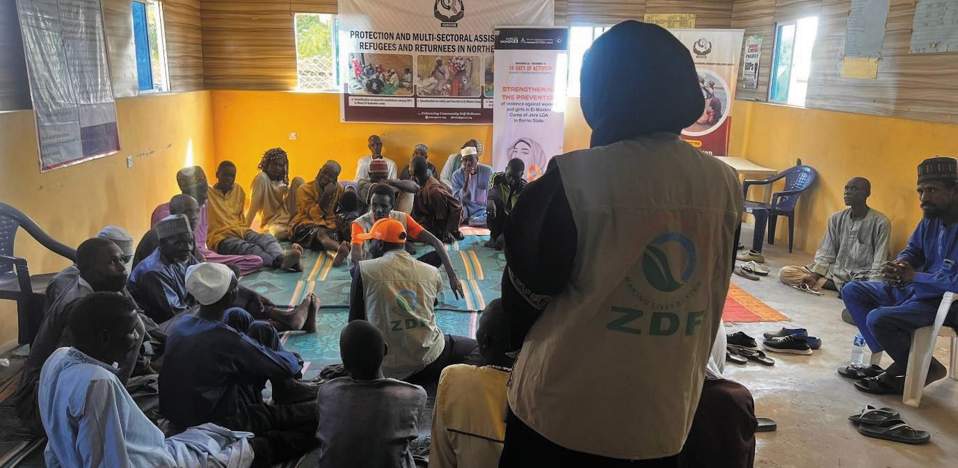 A ZAIDF team member in a ZDF vest addresses a community gathering at Ngomari Junior Secondary School