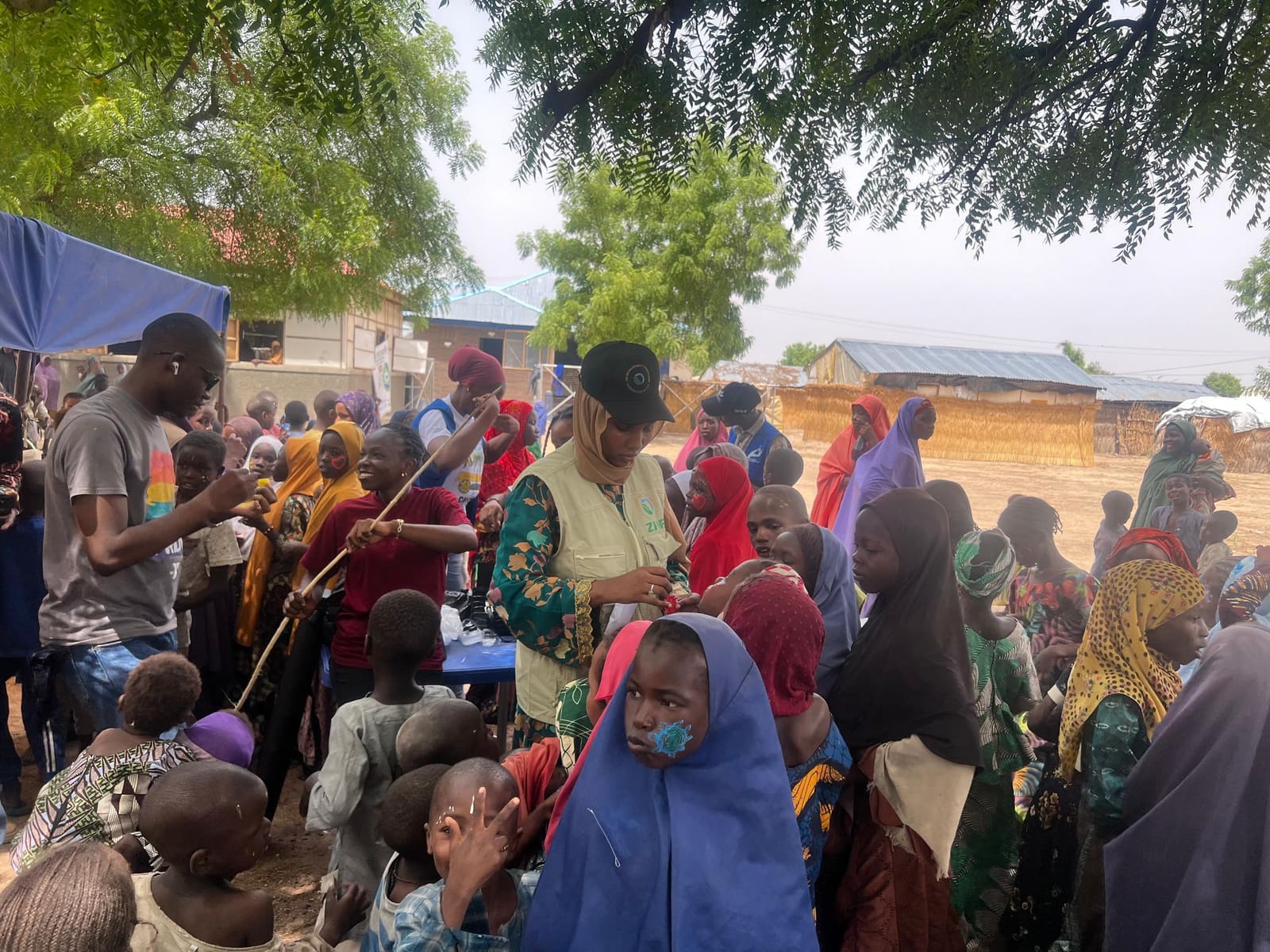 A large gathering of women and children at an outdoor hygiene education session