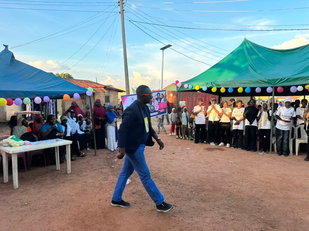 Participants gather at tables under colorful canopies at the start of the menstrual hygiene session in Abuja