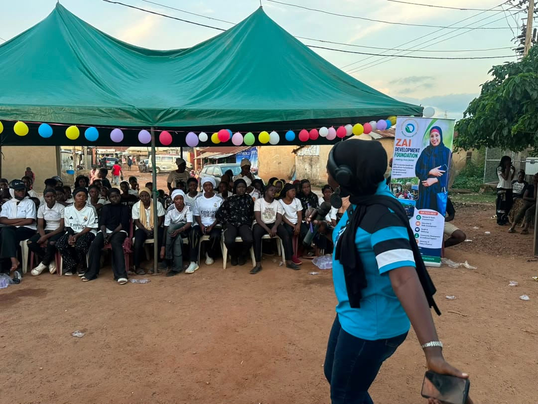 A facilitator speaks to participants seated in rows