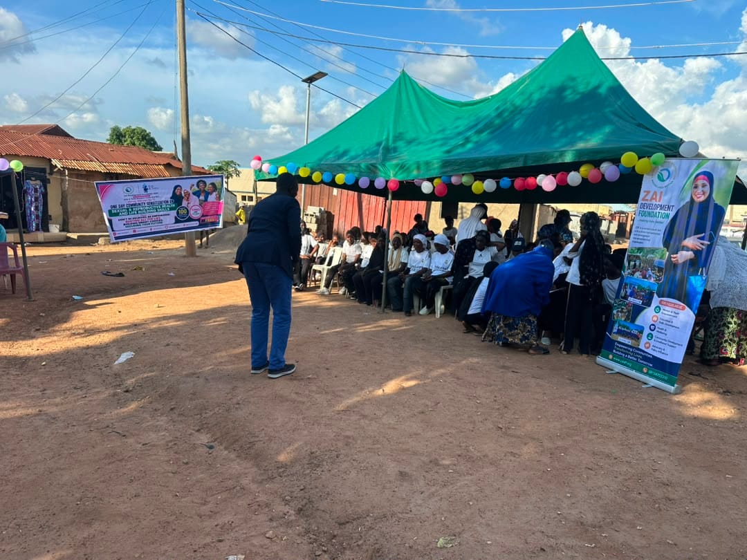 Participants seated in rows beneath green canopies at the session