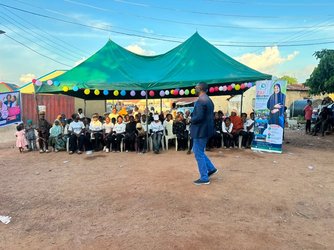 Wide view of the venue with canopies, banners and seated participants