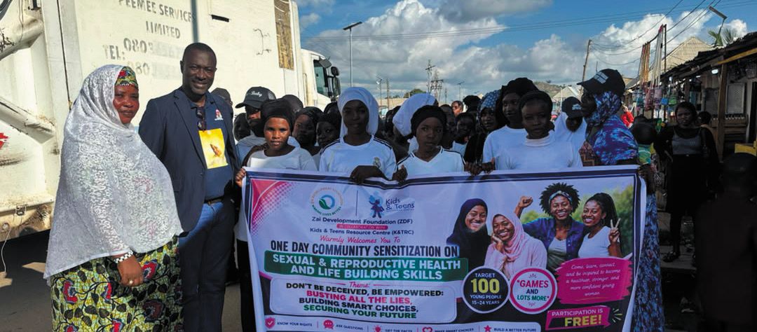 Participants hold the banner for the one-day community sensitization on sexual and reproductive health and life-building skills at Kabusa, Abuja